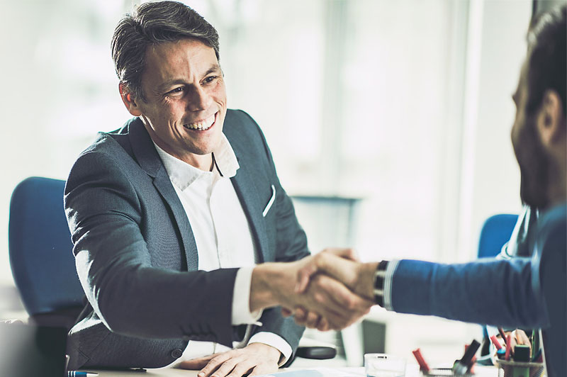 A businessman shakes another person's hand