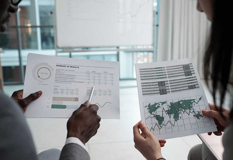 Hands of two young econmists discussing documents