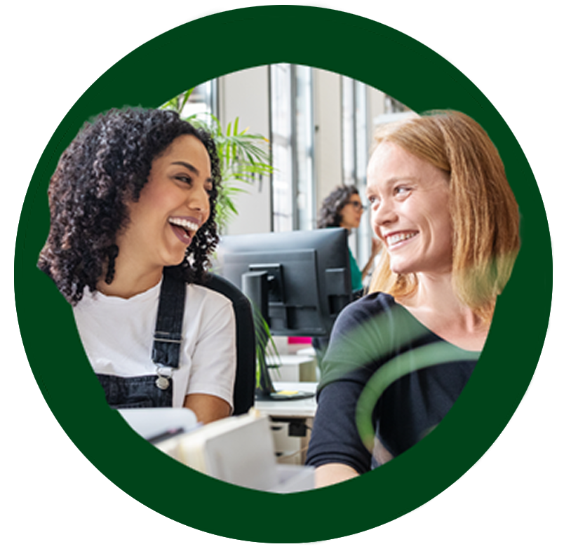 Two women smile and laugh together in a green circle