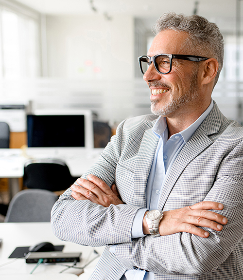 Man in suit, pleased, standing with crossed arms