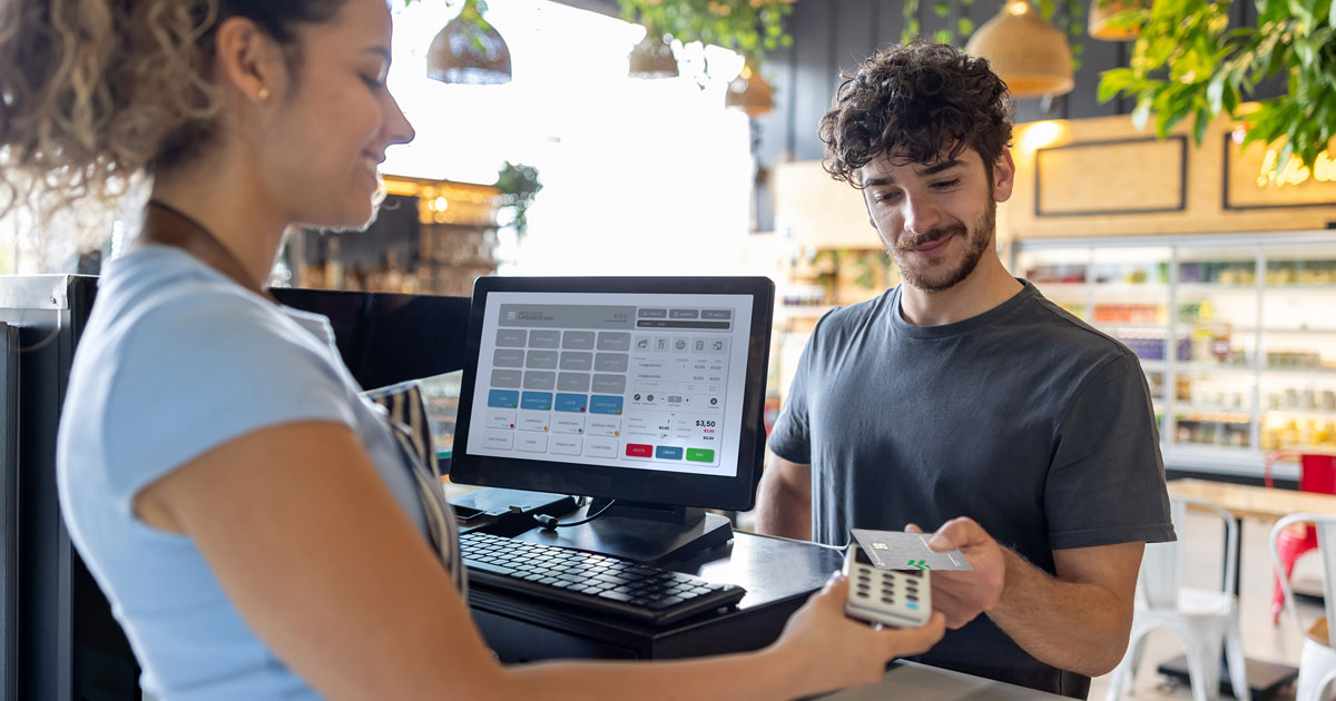 A man uses his debit card to pay for his coffee