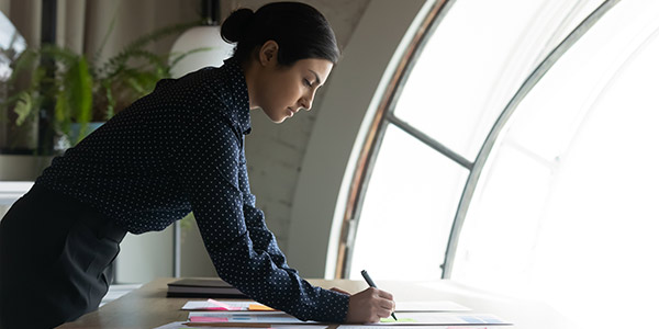 Business Woman writing on office desk
