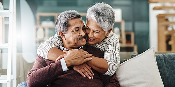 An older couple relaxing on the couch together.