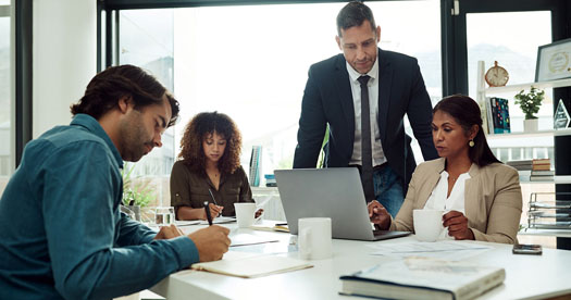 A group of office personnel at a table reviewing IRA and 401(k) documents together