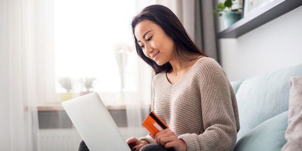 Asian girl making online payment using laptop for shopping at home