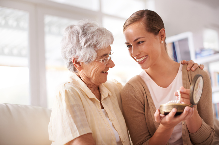 senior woman giving her daughter a pearl necklace