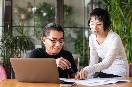 Asian couple talking about the design of their new house.